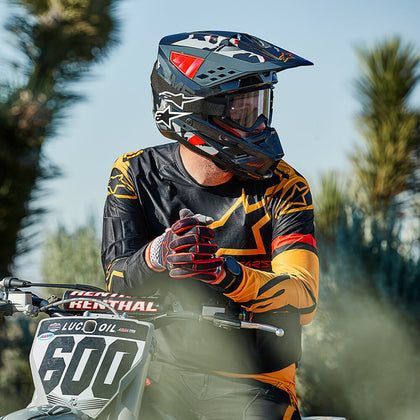 Dirt riding style - motocross rider adjusting gloves on a dirt bike