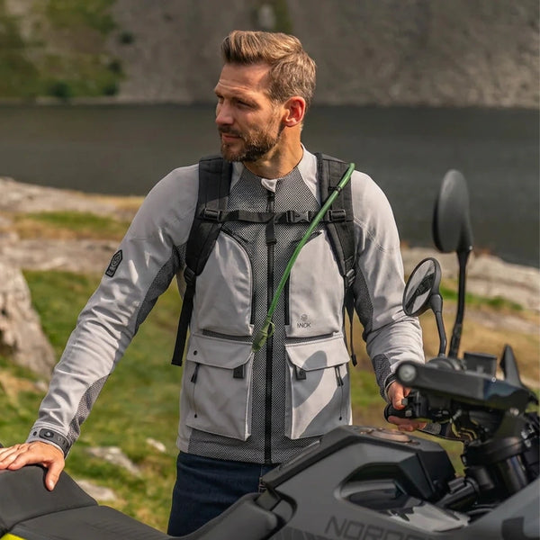 Rider wearing Knox Tor Armoured Shirt and Waterproof Shell beside motorcycle
