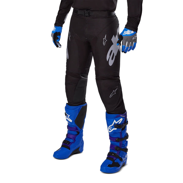 Lower front detail of Alpinestars Racer Graphite motocross pants with motocross boots